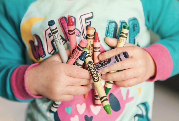 Photo by Kristin Brown toddler holding assorted-color Crayola lot